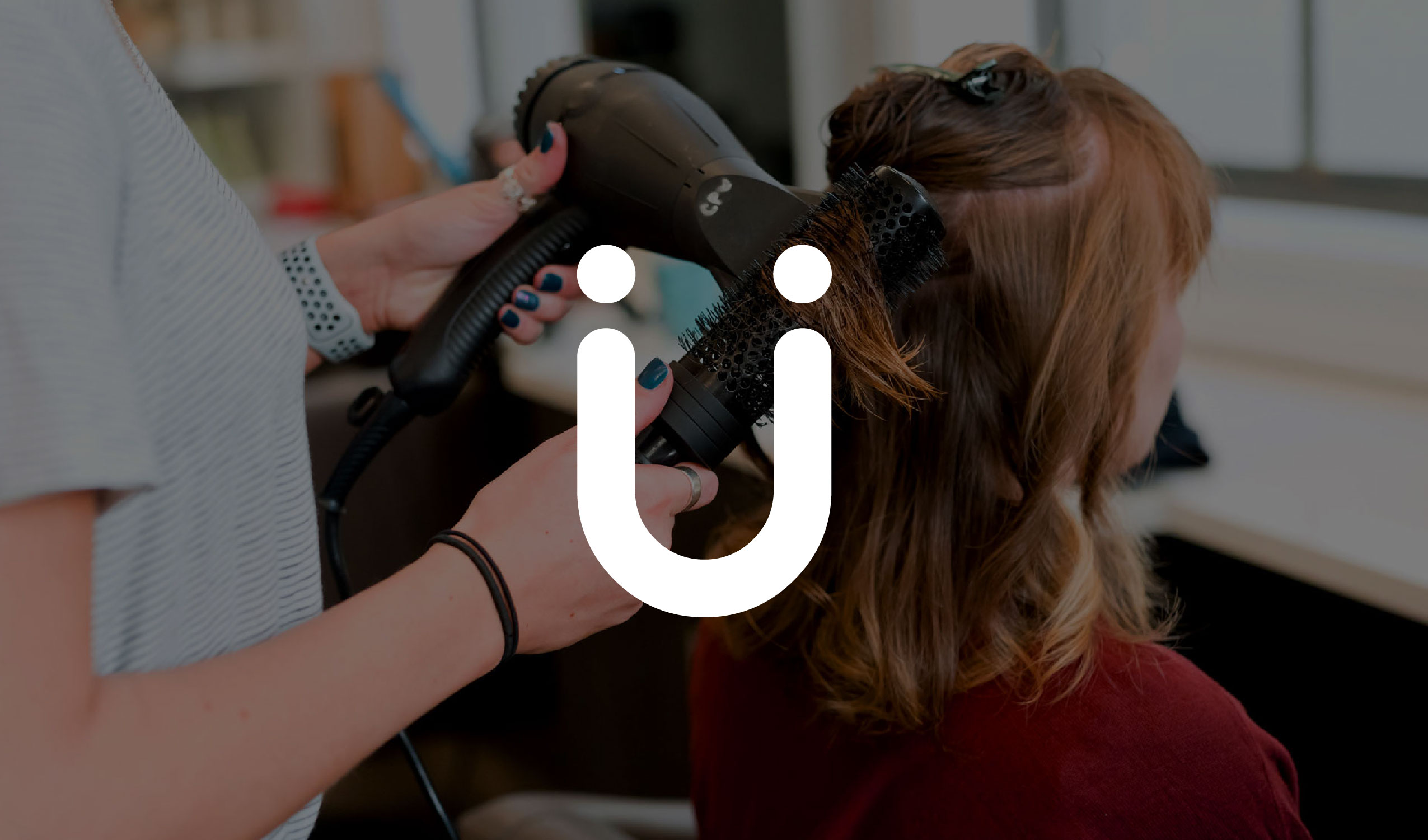 Photo of a hairdresser blow drying a clients hair